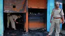 Polisi India mengecek restoran yang terbakar di Bangalore (8/1). Lima pekerja restoran tewas akibat kebakaran tersebut. Menurut Polisi, kurang dari dua minggu kebakaran telah terjadi di restoran lain menewaskan 14 orang. (AFP Photo/Manjunath Kiran)