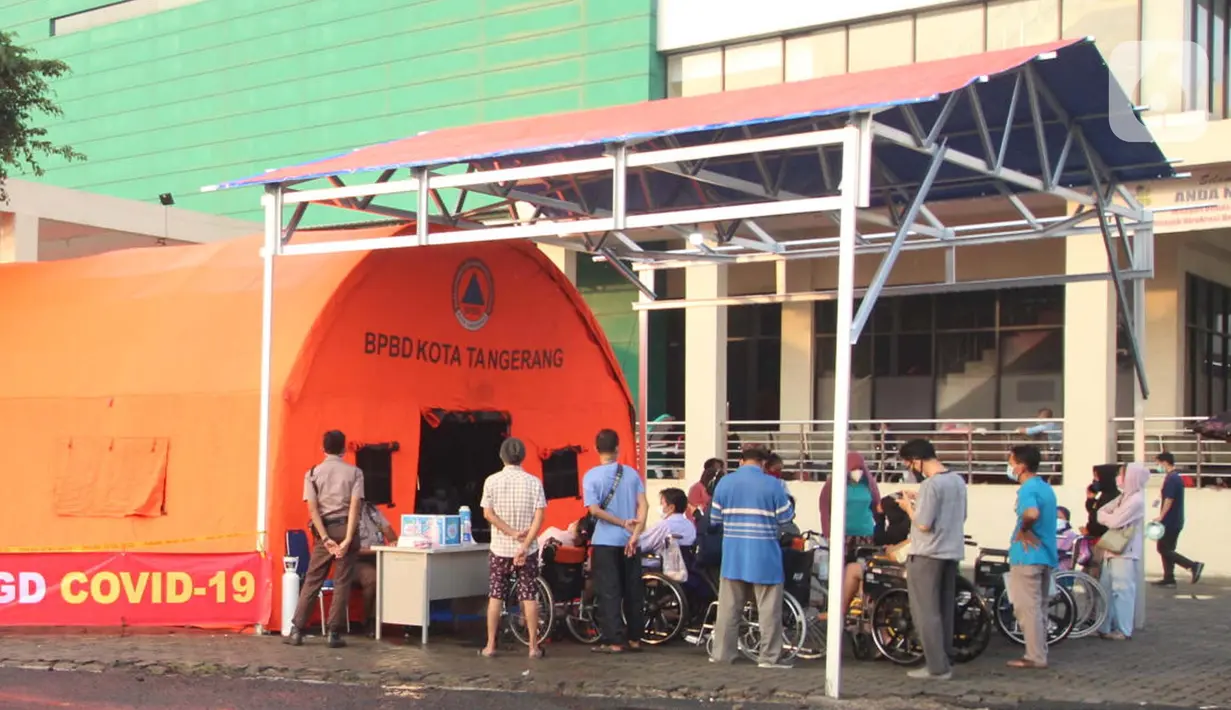 Pasien yang terpapar Covid-19 antre di luar tenda darurat yang didirikan di RSUP dr Sintanala, Kota Tangerang, Rabu (30/6/2021).  Pasien yang mengantre di luar tenda harus menunggu dengan menggunakan Kursi Roda. (Liputan6.com/Angga Yuniar)