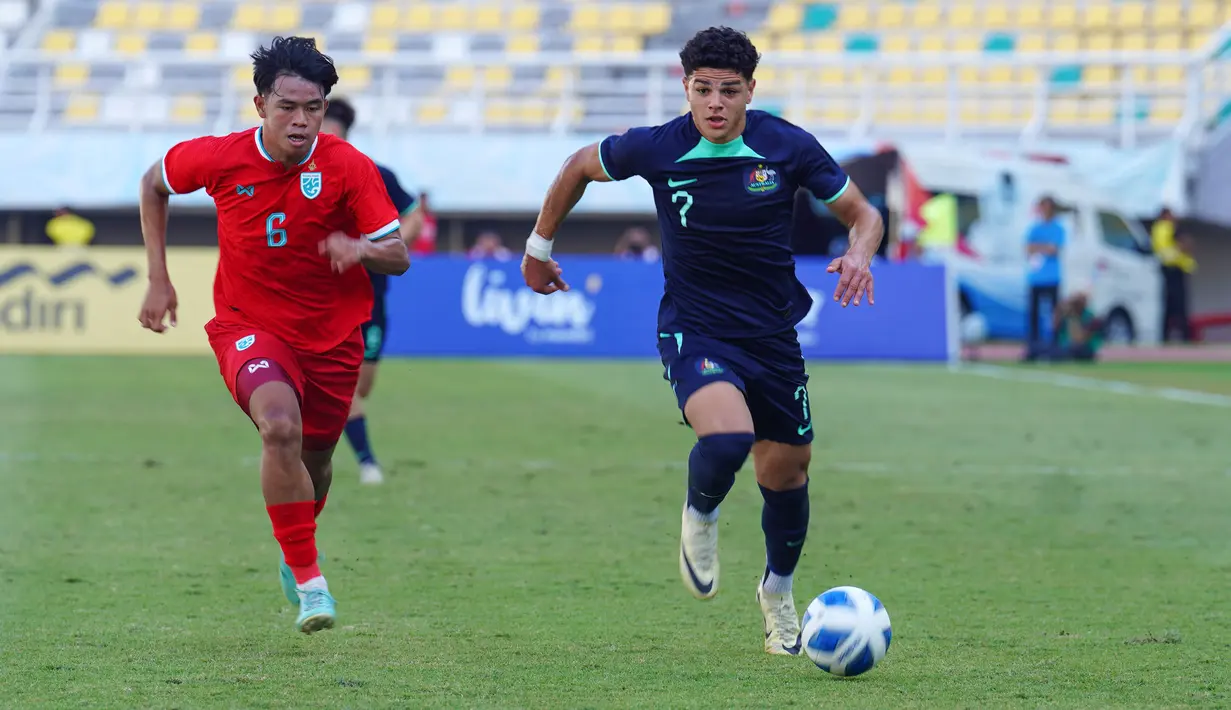Pemain Austalia U-19, Marcus James Younis (kanan) menggiring bola dibayangi pemain Thailand U-19, Rapeephat Padthaisong saat laga semifinal Piala AFF U-19 2024 di Stadion Gelora Bung Tomo, Surabaya, Sabtu (27/07/2024). (Dok. PSSI)