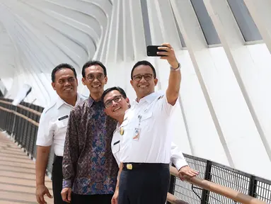 Gubernur DKI Jakarta Anies Baswedan berswafoto saat meresmikan jembatan penyeberangan orang (JPO) di Jalan Jenderal Sudirman, Kamis (28/2). JPO yang diresmikan adalah JPO Gelora Bung Karno dan JPO Bundaran Senayan. (Liputan6.com/Immanuel Antonius)