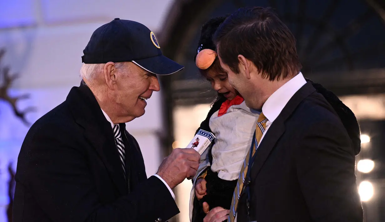 Secara bergantian, anak-anak yang memakai kostum menemui Biden di pintu masuk. (Brendan SMIALOWSKI/AFP)