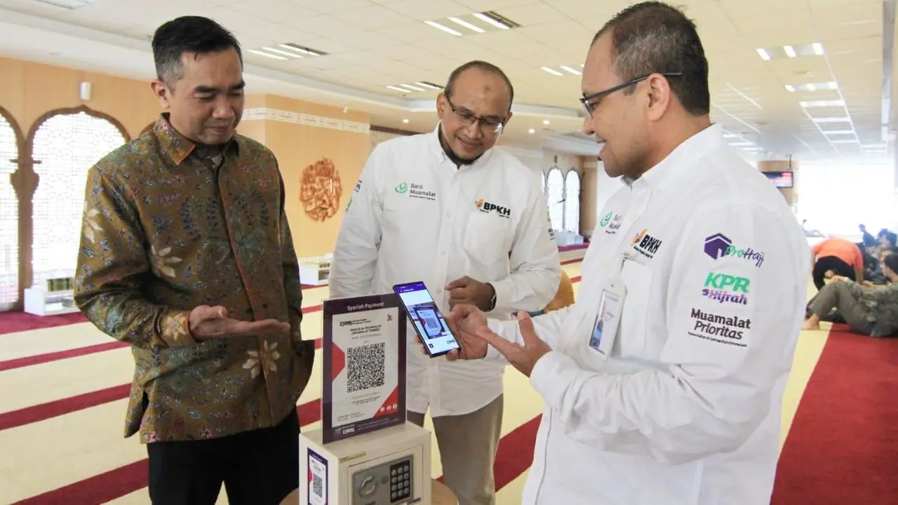 Direktur Operasi Bank Muamalat Indonesia Wahyu Avianto (kanan) didampingi oleh Direktur Kepatuhan Karno (kiri) dan Chief Human Capital Officer Riksa Prakoso (tengah) melakukan donasi menggunakan fitur QR Code pada aplikasi Muamalat DIN