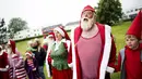 Sejumlah peserta Kongres Santa Claus Dunia 2015 berkumpul untuk bersiap berenang di pantai Bellevue di Copenhagen, Denmark, Minggu (21/7/2015). (REUTERS/Scanpix Denmark/Erik Refner)