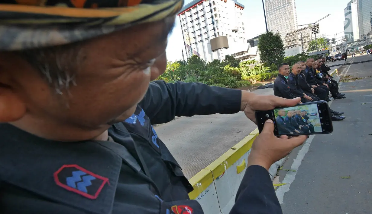 Sejumlah Korps Brimob berfoto disela penjagaan mereka di kawasan MH Thamrin, Jakarta, Jumat (24/5/2019). Usai kerusuhan 22 Mei 2019, penjagaan di kawasan jalan MH Thamrin sampai Jumat, 24 Mei 2019 masih terus dilakukan oleh aparat kepolisian. (Liputan6.com/Herman Zakharia)