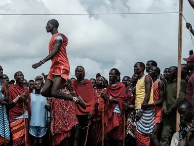 Pria suku Masaai melompat untuk mencapai tali selama mengikuti Olimpiade Maasai 2018 di Kimana, Kenya (15/12). Olimpiade ini inisiatif dari kelompok konservasi internasional yang dipimpin oleh Born Free. (AFP Photo/Yasuyoshi Chiba)