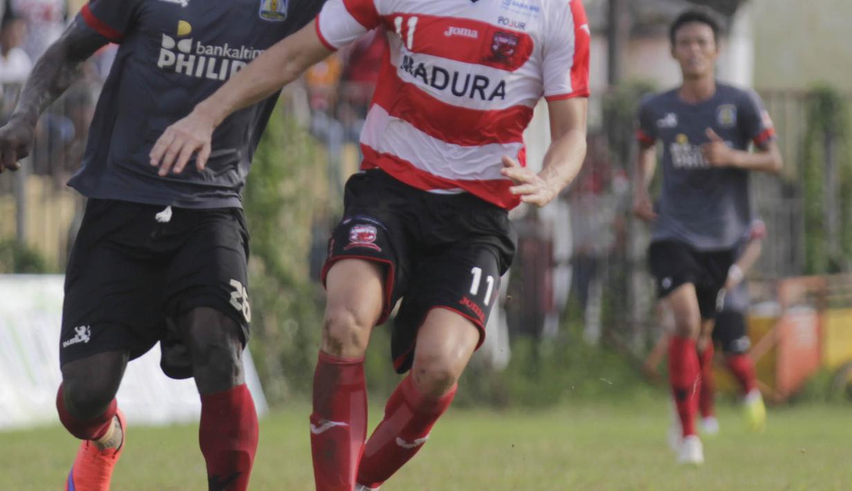 Penyerang Madura United, Pablo Aracil, duel bola atas dengan bek Persiba Balikpapan, Boakay Edy Fodai, pada laga uji coba di Stadion Ahmad Yani, Sumenep, Sabtu (20/2/2016). (Bola.com/Vitalis Yogi Trisna)