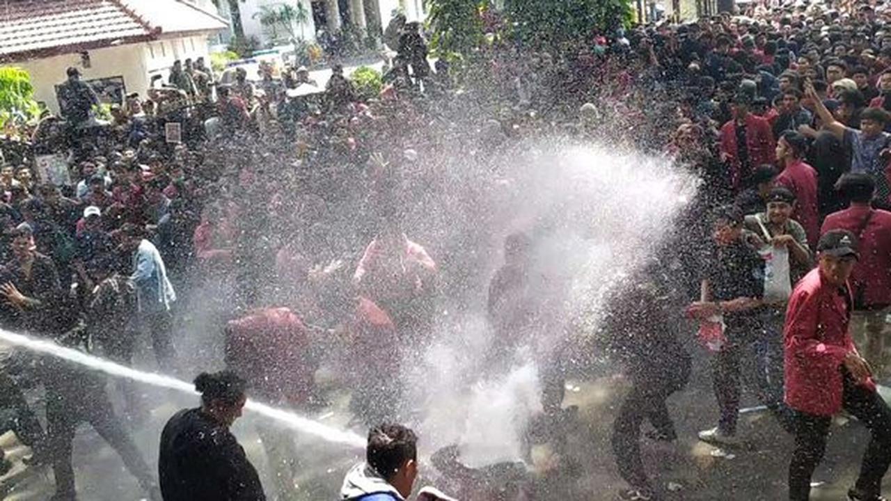 Massa unjuk rasa dihalau polisi dengan semprotan water canon di depan Gedung DPRD Malang. (Merdeka/Darmadi Sasongko)