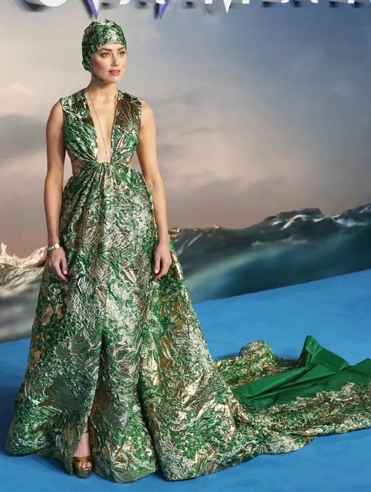 Aktris cantik Amber Heard berpose untuk fotografer setibanya menghadiri premier dunia film 'Aquaman' di London, Senin (26/11). Amber Heard tampil memukau mengenakan gaun plunging hijau keemasan dari Valentino. (AP Photo)