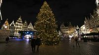 Orang-orang berjalan di sebelah pohon Natal dan dekorasi lainnya di pusat bersejarah Antwerpen, Belgia, 20 Desember 2021. Negara-negara di Eropa mempertimbangkan pembatasan yang lebih ketat guna membendung gelombang baru infeksi COVID-19 yang didorong oleh varian omicron. (AP Photo/Virginia Mayo)