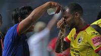 Pemain Sriwijaya FC, Hilton Moreira mebasuh wajahnya dari asap gas airmata pada laga Torabika SC 2016 antara Persija Jakarta vs Sriwijaya FC di  Stadion Utama Gelora Bung Karno (24/6/2016).  (Bola.com/Nicklas Hanoatubun)