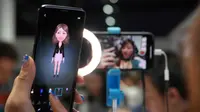 Seorang wanita mencoba ponsel Samsung Galaxy S9 saat acara Samsung Galaxy S9 Unpacked di Barcelona, Spanyol (25/2). Samsung akan menjual kedua smartphone ini sebulan setelah peluncurannya, yakni April 2018. (AFP Photo/Lluis Gene)