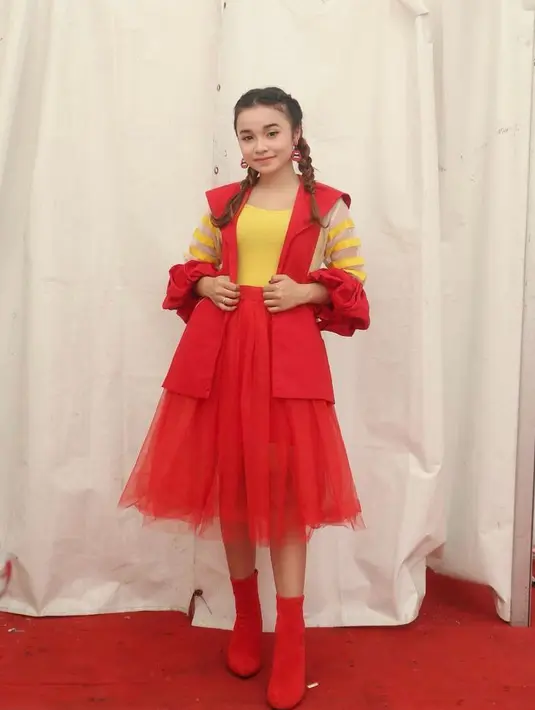 Perpaduan warna merah dan kuning terang, juga detail manis dari rok tutu dan puff di bagian lengan, menambah keceriaan style Tasya Rosmala. (Instagram/tasya_ratu_gopo).