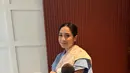 Di foto ini terlihat Nagita Slavina tampil menggendong bayi dalam balutan outfit setelan berwarna biru dan sling bag kuning. [Foto: Instagram/raffinagita1717]