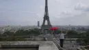 Aksi kedua kalinya akrobatik Nathan Paulin meniti seutas tali slackline yang dipasang pada ketinggian 70 meter antara Menara Eiffel dan Theater Chaillot di Paris, Minggu (19/9/2021). Pria Prancis tersebut mendapat tepuk tangan yang meriah dari penonton. (AP Photo/Francois Mori)