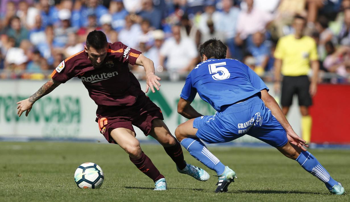 Striker Barcelona, Lionel Messi, berusaha melewati gelandang Getafe, Markel Bergara pada laga La Liga di Stadion Alfonso Perez, Sabtu (16/9/2017). Barcelona menang 2-1 atas Getafe. (AP/Francisco Seco)