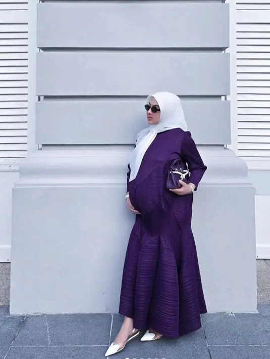 Untuk hadirkan nuansa standout, dress ungu disertai hijab putih hadirkan gaya yang begitu sempurna. [Foto: Instagram/ Princess Syahrini]