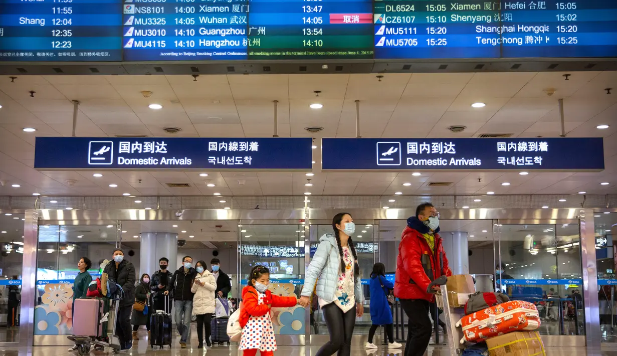 <p>Penerbangan dari Wuhan Ditutup: Pelancong berjalan melintasi papan informasi tentang penerbangan dari Wuhan telah dibatalkan di Bandara Internasional Ibu Kota Beijing pada Kamis (23/1/2020). China menangguhkan semua transportasi dari dan ke kota pusat penyebaran virus corona. (AP/Mark Schiefelbein)</p>
