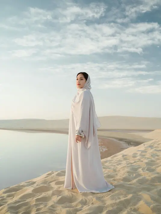 Nagita Slavina sempat menghabiskan waktu di Qatar. Di momen ini tentu tak dilewatkan tanpa mengabadikan momen di padang pasirnya, terlihat Nagita mengenakan gamis yang senada dengan syal panjang yang dipasangkan di kepalanya. Dengan setelan gamis bernuansa netral ini, tampilan Nagita yang terlihat sederhana ini justru sangat menarik untuk disimak. Foto: Instagram.