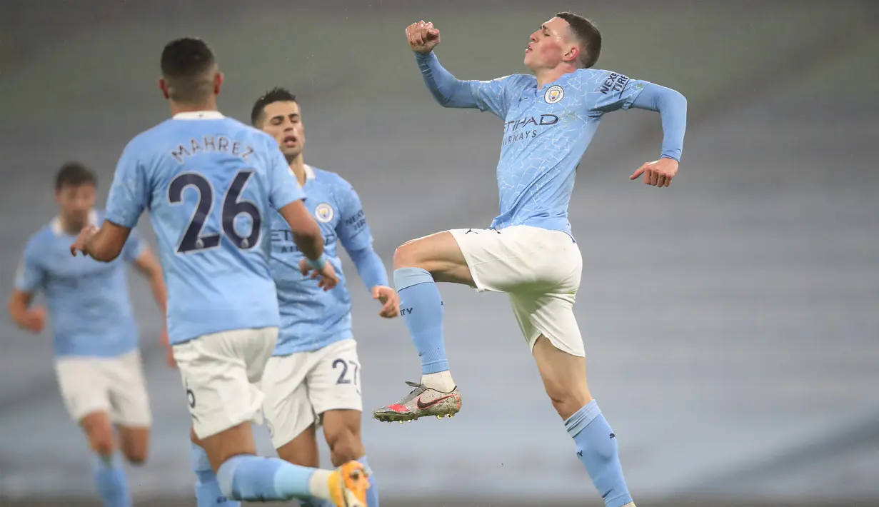 Gelandang Manchester City, Phil Foden (kanan) melakukan selebrasi usai mencetak gol ke gawang Brighton and Hove Albion dalam laga lanjutan Liga Inggris 2020/21 di Etihad Stadium, Rabu (13/1/2021). Manchester City menang 1-0 atas Brighton. (AFP/Clive Brunskill/Pool)