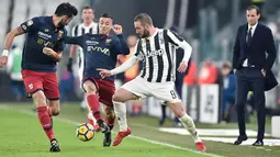 Pemain Juventus, Gonzalo Higuain berebut bola dengan pemain Genoa, Armando Izzo dalam lanjutan pertandingan Serie A di Stadion Allianz, Turin, Senin (22/1). Juventus mengatasi perlawanan Genoa dengan skor 1-0. (Alessandro Di Marco/ANSA via AP)