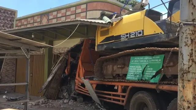 Truk tronton pengangkut alat berat menabrak rumah sekaligus ruko milik warga hingga mengalami kerusakan parah di Lampung Selatan.