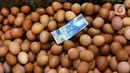 Uang pecahan Rp 50 ribu terlihat di atas tumpukan telur ayam di Pasar Kelapa Dua, Kabupaten Tangerang, Banten, Rabu (29/12/2021). Meroketnya harga telur ayam di sejumlah wilayah jelang pergantian tahun dipicu oleh harga pakan yang tinggi. (Liputan6.com/Angga Yuniar)