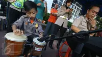 Seorang polisi cilik bermain kendang  saat melakukan kampanye keselamatan berkendara di kawasan Bundaran HI, Jakarta, Minggu (12/3). (Liputan6.com/Immanuel Antonius)