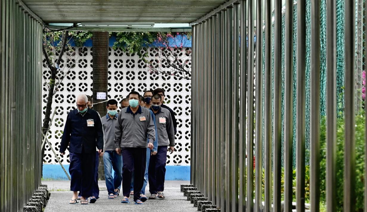 Para tahanan mengenakan masker berjalan di Penjara Taipei di Kota Taoyuan, Taiwan utara (10/3/2020). Lebih dari 4.000 orang telah meninggal dan lebih dari 110.000 telah terinfeksi virus corona di seluruh dunia. (AFP/Sam Yeh)