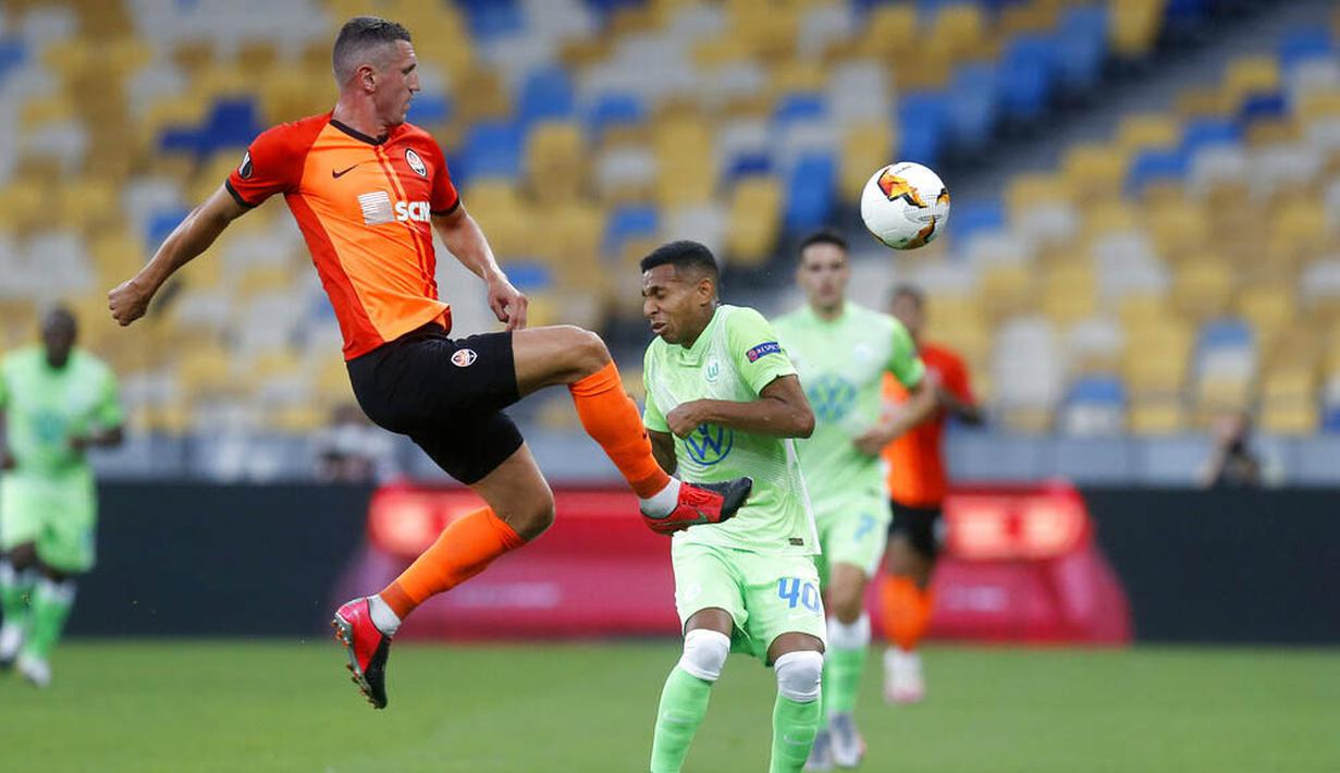 Pemain FC Shakhtar Donetsk, Serhiy Kryvtsov, berebut bola dengan pemain VfL Wolfsburg, Joao Victor, pada laga Liga Europa di Stadion NSK Olimpiyskiy, Kiev, Rabu (5/8/2020). Shakhtar Donetsk menang 3-0 atas Wolfsburg. (AP/Efrem Lukatsky)