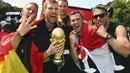 Bastian Schweinsteiger, Per Mertesacker, Manuel Neuer, Kevin Grosskreutz dan Lukas Podolski (dari kiri ke kanan) berpose sambil memegang erat trofi Piala Dunia saat perayaan kemenangan di Berlin, (15/7/2014). (REUTERS/Alex Grimm/Pool)