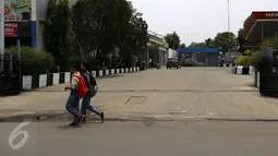 Warga melintas di dekat lokasi penembakan seorang tukang ojek bernama Japra oleh oknum tentara di dekat SPBU kawasan Cibinong, Kabupaten Bogor, Rabu (4/11/2015). (Liputan6.com/Yoppy Renato)