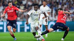 Pemain Real Madrid, Aurelien Tchouameni, berusaha melewati pemain Osasuna pada laga pekan perdana La Liga di Stadion di Santiago Bernabeu, Rabu (20/8/2025) dini hari WIB. (AP Photo/Manu Fernandez)