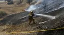 Seorang pemadam kebakaran sedang memadamkan api di hutan kawasan California, AS, Senin (3/8/2015). Sedikitnya 9.000 petugas damkar berjuang mengatasi sebanyak 18 kebakaran hutan yang melanda Negara Bagian California, AS. (Reuters/ Stephen Lam) 