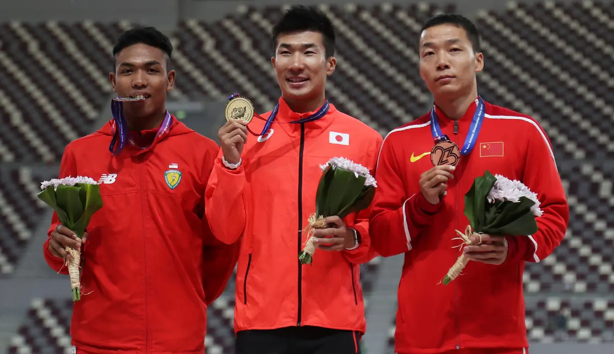 Yoshihide Kiryu dari Jepang, Zhiqiang Wu dari Cina dan Lalu Muhammad Zohri dari Indonesia berpose bersama usai upacara pengalungan medali seusai mengikuti kategori 100 meter dalam Kejuaraan Atletik Asia di Doha, Qatar, Senin (22/4). (REUTERS/Ibraheem Al Omari)
