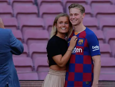 Gelandang asal Belanda Frenkie de Jong (kanan) bersama pacarnya Mikky Kiemeney berpose setelah pengenalan dirinya sebagai pemain baru Barcelona di stadion Camp Nou, Spanyol (5/7/2019). Frenkie de Jong diboyong Barcelona dari Ajax Amsterdam. (AP Photo/Emilio Morenatti)