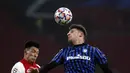 Bek Ajax, Lisandro Martinez berebut bola udara dengan bek Atlanta, Berat Djimsiti pada pertandingan Grup D Liga Champions di Johan Cruyff ArenA di Amsterdam, Belanda, Kamis (10/12/2020). Atalanta memenangkan pertandingan 1-0.  (AP Photo/Peter Dejong)