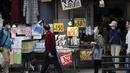 Orang-orang yang mengenakan masker pelindung untuk membantu mengekang penyebaran virus corona berjalan di dekat toko yang menjual masker di Tokyo, Jepang, Rabu (14/10/2020). Tokyo mengonfirmasi lebih dari 170 kasus virus corona baru pada hari Rabu. (AP Photo/Eugene Hoshiko)