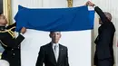 Mantan Presiden AS Barack Obama memamerkan potret resmi dari lukisannya yang akan menjadi koleksi Gedung Putih di Ruang Timur Gedung Putih, Washington, Rabu (7/9/2022). Dalam lukisan itu, Barack Obama memakai jas hitam dan dasi hitam, berdiri dengan latar belakang putih.  (AP Photo/Andrew Harnik)