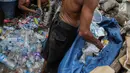 Warga memilah sampah plastik di permukiman liar di kawasan Bypass, Pramuka, Jakarta Timur, Rabu (21/2). Penertiban pemulung yang menduduki lokasi tersebut tak juga dilakukan. (Liputan6.com/Faizal Fanani)