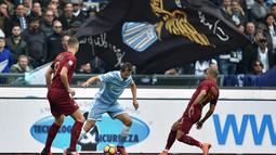Pemain Lazio, Senad Lulic (tengah) mencoba melewati dua pemain AS Roma  pada laga Derby della Capitale di Olympic Stadium, Roma, Italia, (4/12/2016). AS Roma menang 2-0.  (AFP/Alberto Pizzoli)