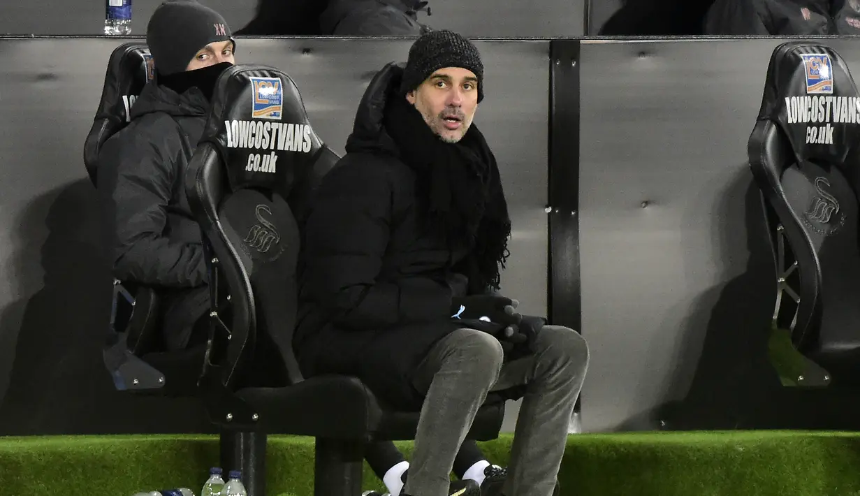 Manajer tim Manchester City, Pep Guardiola mengamati penampilan timnya menghadapi Swansea City dalam laga babak kelima Piala FA 2020/21 di Liberty Stadium, Rabu (10/2/2021). Manchester City menang 3-1 atas Swansea City. (AFP/Rebecca Naden/Pool)