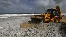 Sebuah alat berat menyingkirkan puing-puing dari kapal kontainer MV X-Press Pearl yang terdampar di sebuah pantai di Kolombo, Jumat (28/5/2021). Akibat kebakaran tersebut, limbah dari kapal mencemari laut Sri Lanka hingga terdampar ke pinggir pantai.  (Ishara S. KODIKARA/AFP)