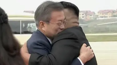 Presiden Korea Selatan, Moon Jae-in (kiri) memeluk pemimpin Korea Utara, Kim Jong-un setibanya di Pyongyang, Selasa (18/8). Kedatangan Moon Jae-in ke negara tersebut adalah untuk pertemuan ketiga dengan Kim Jong-un. (Korea Broadcasting System via AP)