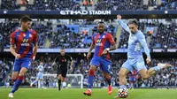 Pemain Manchester City Jack Grealish (kanan) menendang bola di depan pemain Crystal Palace pada pertandingan Liga Inggris di Etihad Stadium, Manchester, Inggris, 30 Oktober 2021. Crystal Palace menang 2-0. (Oli SCARFF/AFP)