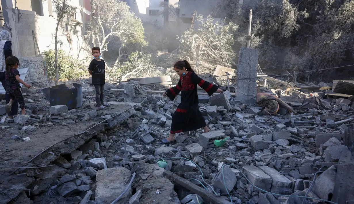 Seorang anak perempuan berjalan di atas puing-puing saat warga Palestina memeriksa lokasi serangan Israel semalam, di Jabalia, Jalur Gaza tengah, pada 30 Mei 2025. (Bashar TALEB/AFP)