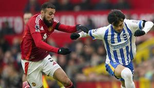 Bek Manchester United, Noussair Mazraoui beradu kecepatan melawan gelandang Brighton, Kaoru Mitoma. (c) AP Photo/Dave Thompson