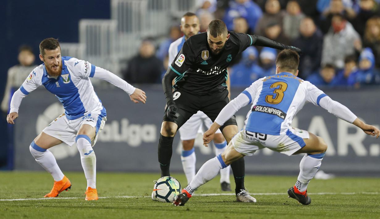 Aksi pemain Real Madrid, Karim Benzema (tengah) melewati kepungan para pemain Leganes pada lanjutan La Liga Santander di Butarque stadium, Leganes, (21/2/2018). Real Madrid menang 3-1.  (AP/Francisco Seco)