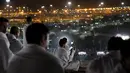 Jemaah calon haji mengabadikan gambar saat berada di Bukit Jabal Rahmah di luar kota suci Mekah, Arab Saudi (30/8).  Bukit Jabal Rahmah dikenal sebagai bukit kasih sayang. (AP Photo / Khalil Hamra)
