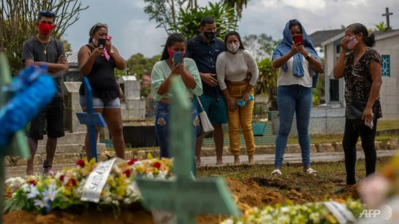 Kerabat korban COVID-19 menghadiri pemakaman di Brasil, di mana jumlah kematian setiap hari melonjak. (AFP / MICHAEL DANTAS)