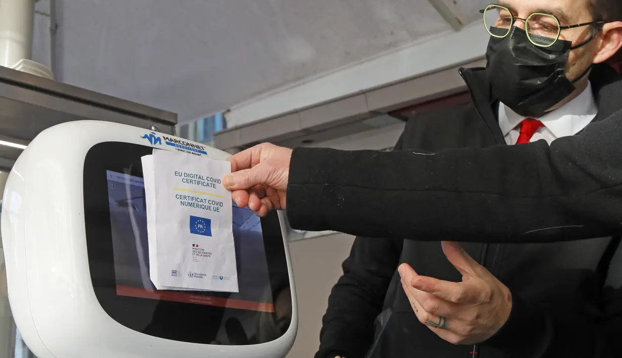 Mesin memeriksa kartu vaksin seorang pria di sebuah restoran di Lille, Prancis utara, Senin (24/1/2022). Aturan yang mulai berlaku pada hari Senin mewajibkan “vaksin pass” bagi warga yang ingin mengakses tempat publik. (AP Photo/Michel Spingler)
